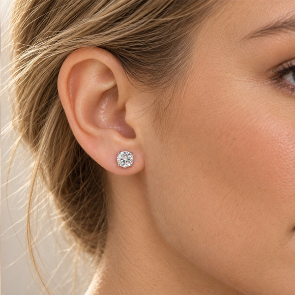 Round brilliant diamond stud earring in white gold, shown worn on the ear.